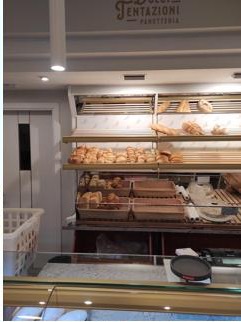 Scaffale con pane e brioche fresche